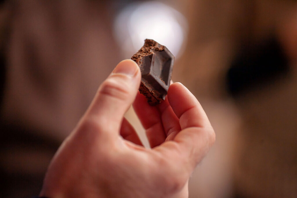 Tros de xocolata artesanal agafat entre dits durant un taller de xocolata.